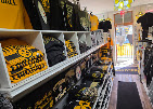 Aisle of shelves stacked with black and gold apparel